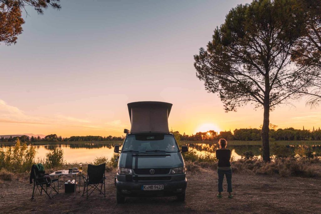 Camping in Spanien - Freistehen am See im VW Camper mit Aufstelldach bei Sonnenuntergang