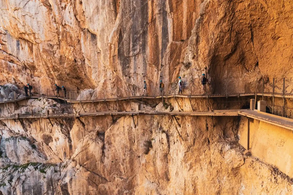 Wandern auf schmalen Holzstegen in schwideleregender Höhe auf dem Caminito del Rey
