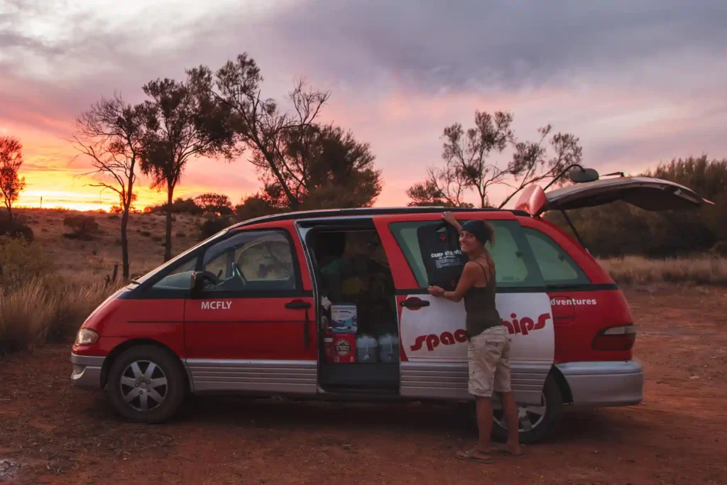 Solardusche wird an Schiebetür eines Mini-Campers aufgehangen